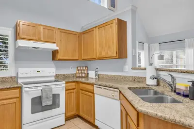 a kitchen with white appliances and wooden cabinets at Family Resort Condo Disney 5 miles in Kissimmee