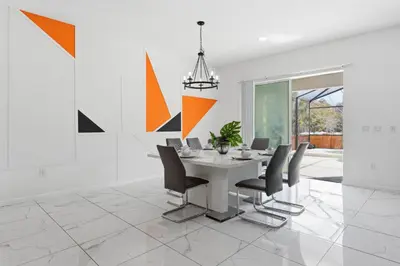 a dining room with a table and chairs at Chic Modern Escape 12BR Pool and Game Room in Kissimmee