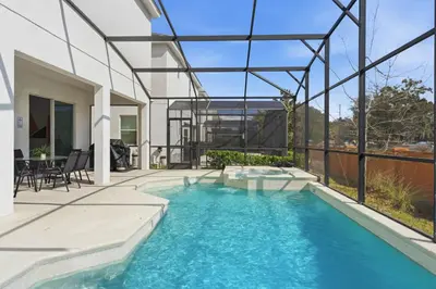 a swimming pool in the backyard of a house at Chic Modern Escape 12BR Pool and Game Room in Kissimmee