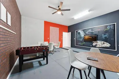 a room with a ping pong table and a dining room at Chic Modern Escape 12BR Pool and Game Room in Kissimmee