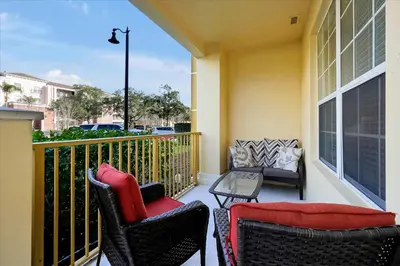 a balcony with two chairs and a table at Beautiful Condo, Near Epic Universe and OCCC-2018 by Vista Cay Resort in Orlando
