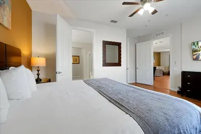 a bedroom with a large white bed with a ceiling fan at Beautiful Condo, Near Epic Universe and OCCC-2018 by Vista Cay Resort in Orlando