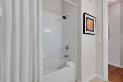 a white bathroom with a tub and a shower at Beautiful Condo, Near Epic Universe and OCCC-2018 by Vista Cay Resort in Orlando