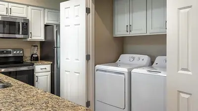 a kitchen with white cabinets and white appliances at Orange Lake Vacation Time in Orlando