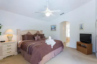 a bedroom with a bed and a flat screen tv at Private Pool with spa and Game Room Near Disney in Kissimmee