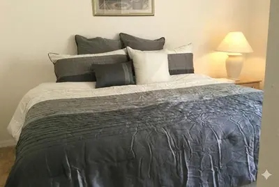 a bedroom with a large bed with gray and white pillows at Private Pool with spa and Game Room Near Disney in Kissimmee