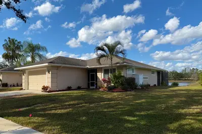 a house with a palm tree in the yard at Disney World, Universal Epic Waterfront Modern Home - Private Pool And Game Room in Kissimmee