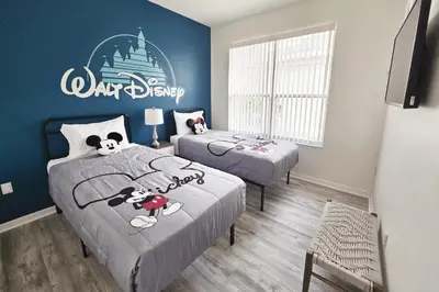 a bedroom with two beds and a disney sign on the wall at Disney World, Universal Epic Waterfront Modern Home - Private Pool And Game Room in Kissimmee