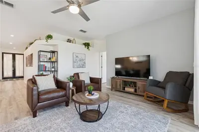 a living room with two chairs and a flat screen tv at Disney World, Universal Epic Waterfront Modern Home - Private Pool And Game Room in Kissimmee