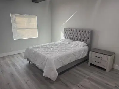 a bedroom with a bed and a nightstand and a window at Lakefront Luxury w Private Dock Sunrises in Orlando