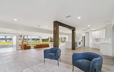 a living room with two blue chairs and a kitchen at Lakefront Luxury w Private Dock Sunrises in Orlando