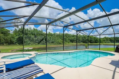 a large swimming pool with a glass roof at Luxury 7BR w Pool Lake View at Berkley in Kissimmee