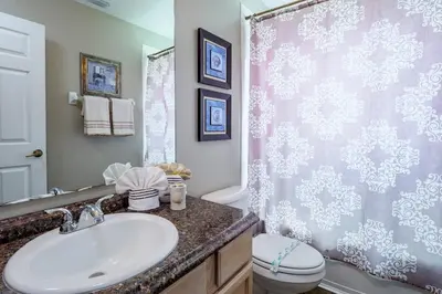 a bathroom with a sink and a shower curtain at Luxury 7BR w Pool Lake View at Berkley in Kissimmee