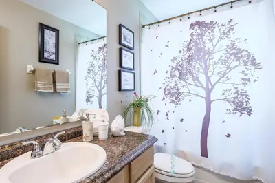 a bathroom with a shower curtain with a tree on it at Luxury 7BR w Pool Lake View at Berkley in Kissimmee