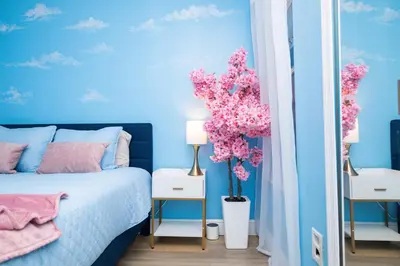 a blue bedroom with blue walls and pink flowers at 3BR Disney Home with Pool , Arcade and Hot Tub in Kissimmee