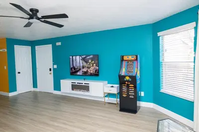a living room with a video game system on the wall at 3BR Disney Home with Pool , Arcade and Hot Tub in Kissimmee