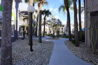 a sidewalk with palm trees and a street light at Condo Epic Universal Disney Free Parking in Orlando
