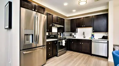 a kitchen with wooden cabinets and a stainless steel refrigerator at Vista Cay Resort Near Parks Convention Center in Orlando
