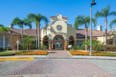 a building with palm trees in front of a street at Vista Cay Resort Near Parks Convention Center in Orlando