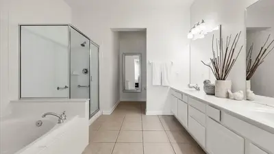 a white bathroom with a tub and a sink at Upstay Great 3BR Condo w Scenic Views & Patio in Orlando