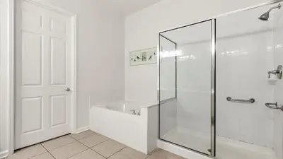a white bathroom with a shower and a bath tub at Upstay Great 3BR Condo w Scenic Views & Patio in Orlando