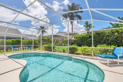 a swimming pool with two chairs and a table at Minutes from Disney Themed 2 Bd Villa with Private Pool home in Orlando