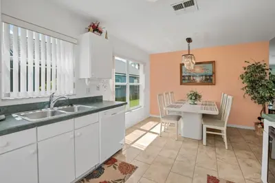 a kitchen with a sink and a table with chairs at Minutes from Disney Themed 2 Bd Villa with Private Pool home in Orlando