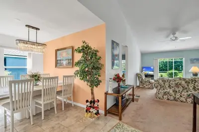 a dining room and living room with a table and chairs at Minutes from Disney Themed 2 Bd Villa with Private Pool home in Orlando