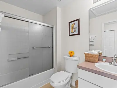 a white bathroom with a toilet and a sink at 4bd Villa Near Epic Universe and Disney with private Pool townhouse in Kissimmee