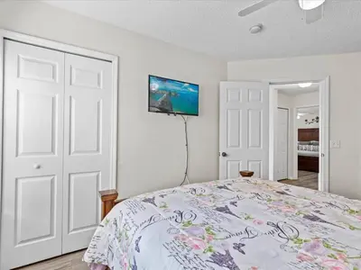 a bedroom with a bed and a tv on the wall at 4bd Villa Near Epic Universe and Disney with private Pool townhouse in Kissimmee