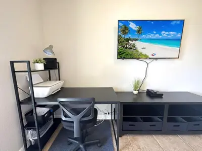 a desk with a computer and a monitor on a wall at Very Near Disney 3 Bd Condo Walmart 1 min away townhouse in Orlando