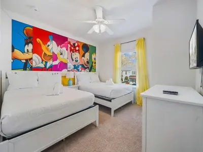 a bedroom with two beds and a painting on the wall at Elegant Townhome at West Lucaya in Kissimmee