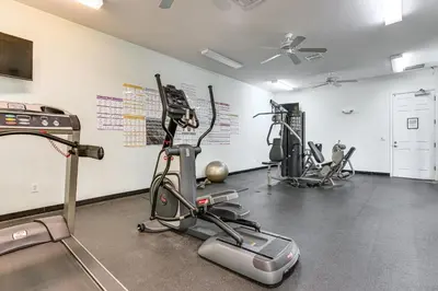a gym with treadmills and ellipticals in a room at 5 Mi to WDW! Spacious Resort Escape with Pool Access in Kissimmee