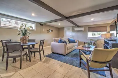 a living room with a couch and a table and chairs at Charming Lakefront Apt Near Disney in Orlando