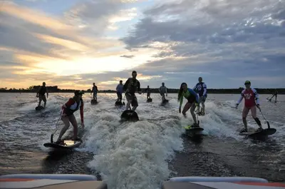 a group of people on surfboards in the water at Charming Lakefront Apt Near Disney in Orlando