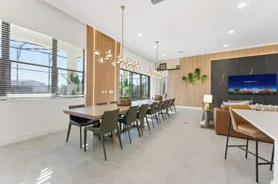 a dining room with a table and chairs and a couch at Paradiso’s Luxurious New Home w 15 Ensuites in Orlando