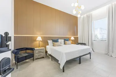 a bedroom with a large bed and a chair at Paradiso’s Luxurious New Home w 15 Ensuites in Orlando