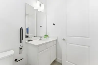 a white bathroom with a sink and a mirror at Paradiso’s Luxurious New Home w 15 Ensuites in Orlando