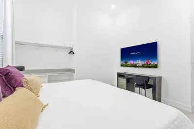a bedroom with a bed and a tv on a wall at Paradiso’s Luxurious New Home w 15 Ensuites in Orlando