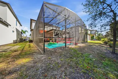 an exterior view of a glass house with a swimming pool at Casita Coco - Private Pool - Foosball - BBQ in Kissimmee