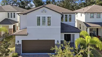 a white house with a garage at Casita Coco - Private Pool - Foosball - BBQ in Kissimmee