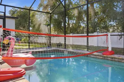 a pool with a net in a swimming pool at Casita Coco - Private Pool - Foosball - BBQ in Kissimmee