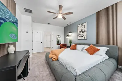 a bedroom with a large bed and a desk at Resort-Style Living w Private Pool & Amenities in Kissimmee