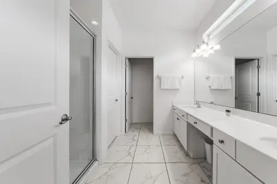 a white bathroom with two sinks and a mirror at 9 BR Family Home 8 Min to Disney SON104 in Kissimmee