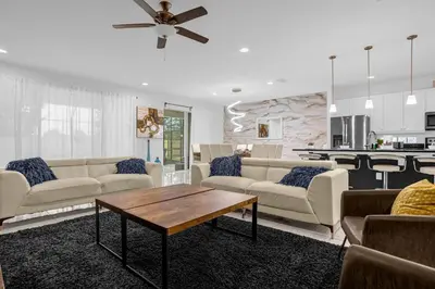 a living room with couches and a table and a kitchen at 9 BR Family Home 8 Min to Disney SON104 in Kissimmee