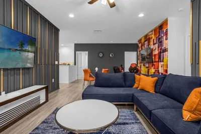 a living room with a blue couch and a table at 9 BR Family Home 8 Min to Disney SON104 in Kissimmee