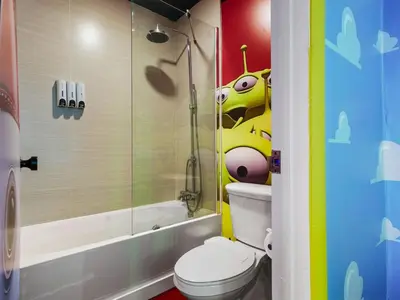 a bathroom with a toilet with a cartoon character on the wall at Toy Story Magic Studio Close to Disney in Kissimmee