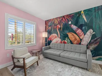 a living room with a couch and a flower mural at Florida vibe suite near Epic Universe & Universal in Orlando