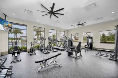 a gym with several treadmills and exercise equipment and windows at 2026 NEW 12Bedrooms12Bathroom At Paradiso Grande in Orlando