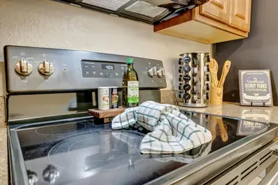 a kitchen with a stove with a towel on the counter at 10 Mins To Disney NO FEES Heated Pool & Hot Tub in Orlando